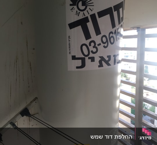 דוד שמש עם מדבקה של חברת אימייל ומספר טלפון